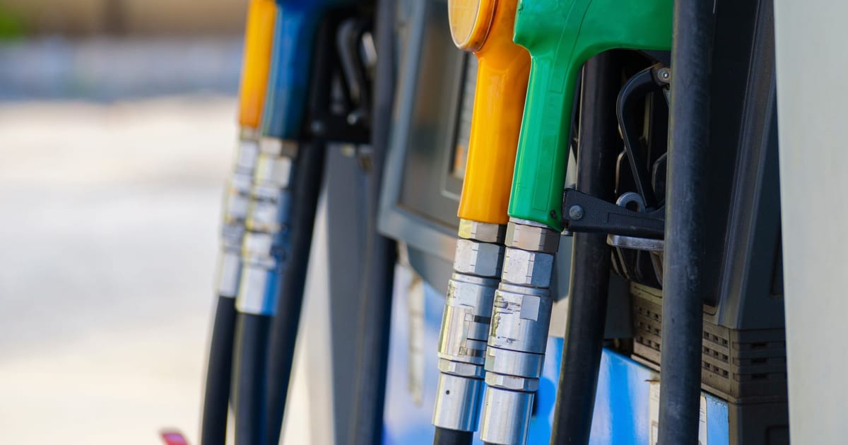 Fuel pump nozzles in different colours at a filling station.