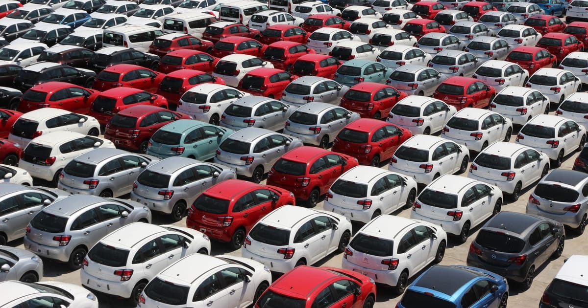 Rows of cars of different lengths seen from above in a storage compound.
