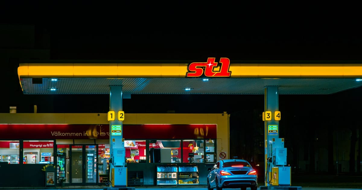 A car refuelling at a filling station at night.